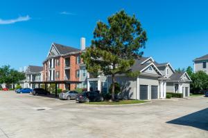 Apartments Rentals in Conroe, TX - Apartment Building Exterior with Parking Area and Garages