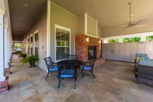 Apartments in Conroe, Texas - Outdoor Patio with Seating and Fireplace & Package Hub